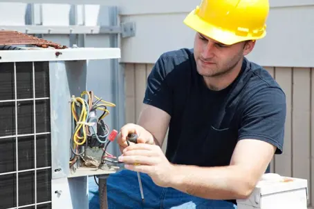 HVAC technician repairs an outdoor unit, working on the wires.